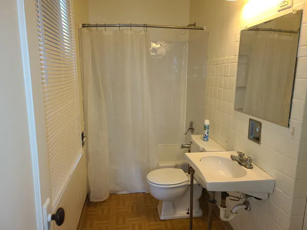 a bathroom with a sink a toilet a mirror and shower