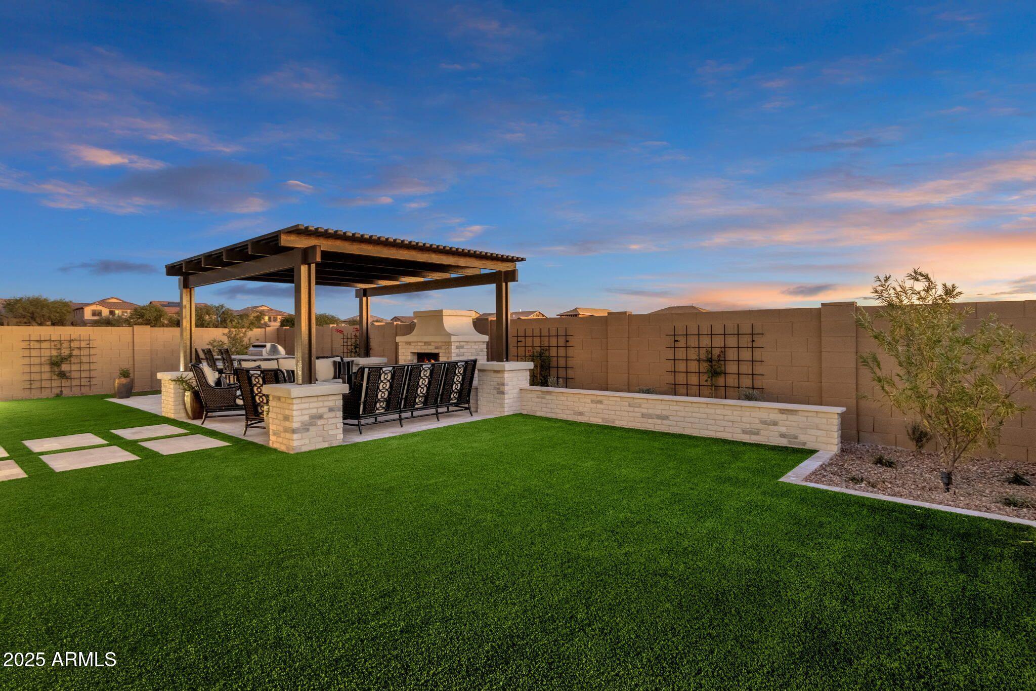 2626 East Russell Street Mesa, AZ 85213 - Photo 17 of 25 a view of a patio with couches and table and chairs under an umbrella
