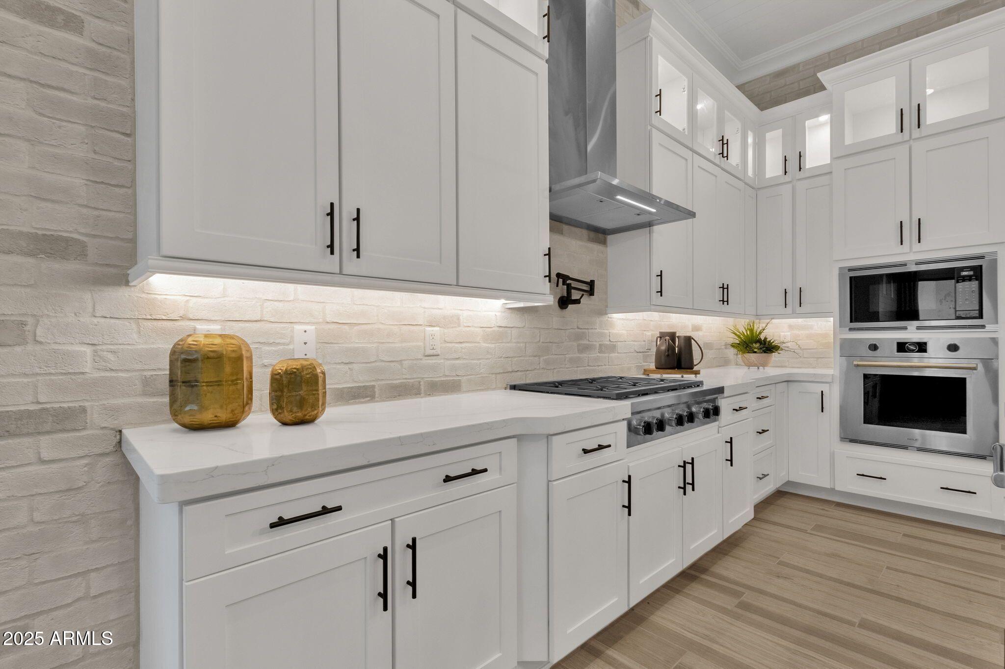 2626 East Russell Street Mesa, AZ 85213 - Photo 4 of 25 a kitchen with stainless steel appliances granite countertop a sink a stove and a wooden floors