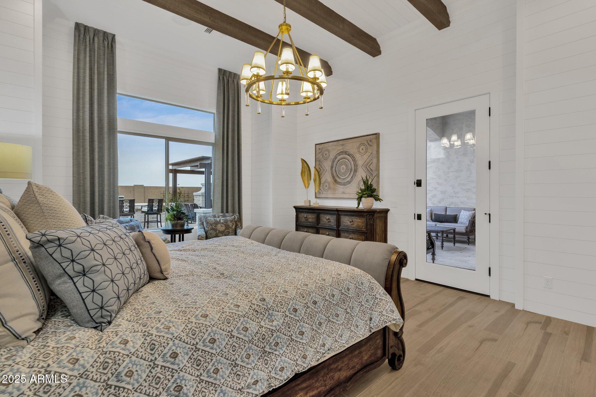 2626 East Russell Street Mesa, AZ 85213 - Photo 8 of 25 a bedroom with a bed and a chandelier