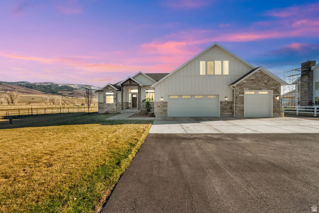 352 East Boulderville Road Oakley, UT 84055 - Photo 39 of 62 View of front of home featuring board and batten siding, driveway, stone siding, and a garage