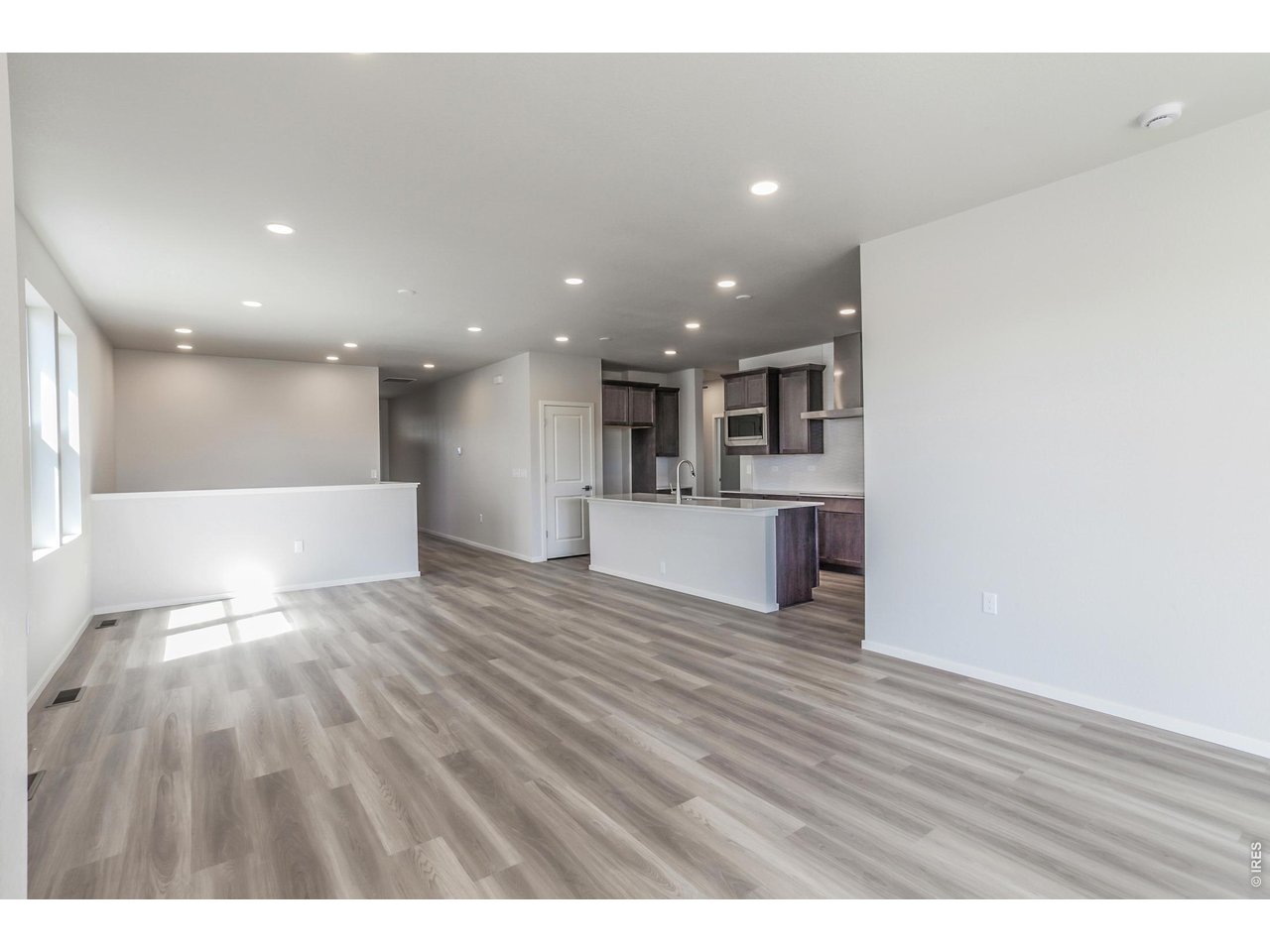 792 Chatter Road Windsor, CO 80550 - Photo 12 of 49 a view of kitchen with kitchen island wooden floor center island and stainless steel appliances