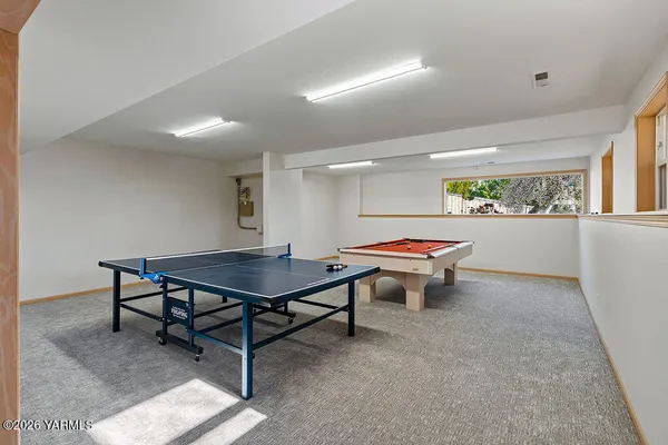 a room with furniture pool table and windows