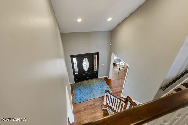 a view of a hallway with wooden floor and a potted plant