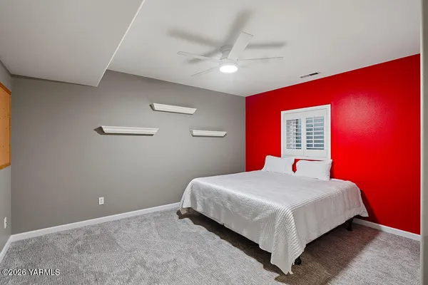 a bedroom with a bed and a ceiling fan