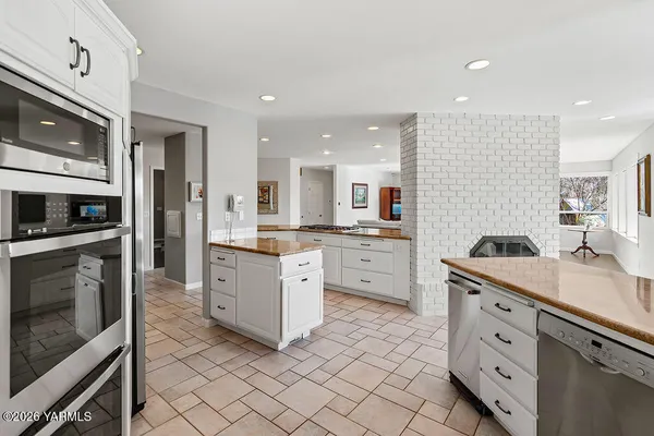 a kitchen with granite countertop cabinets stainless steel appliances and a counter space