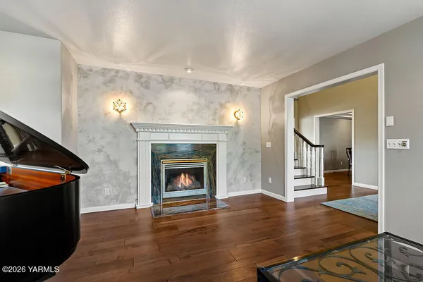 a view of a livingroom with wooden floor and a fireplace