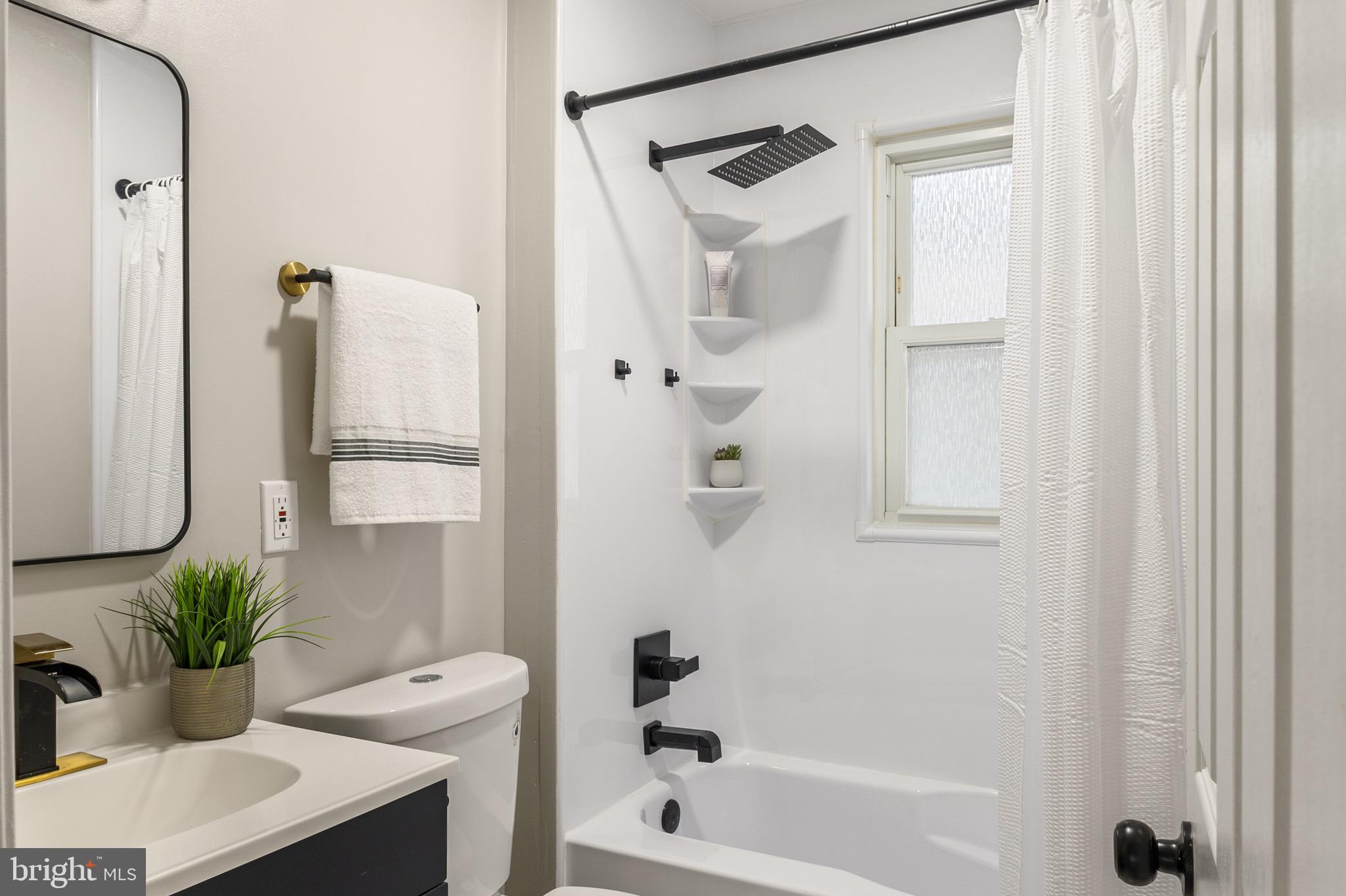 4042 6th Street Baltimore, MD 21225 - Photo 20 of 31 a bathroom with a tub shower sink and a mirror
