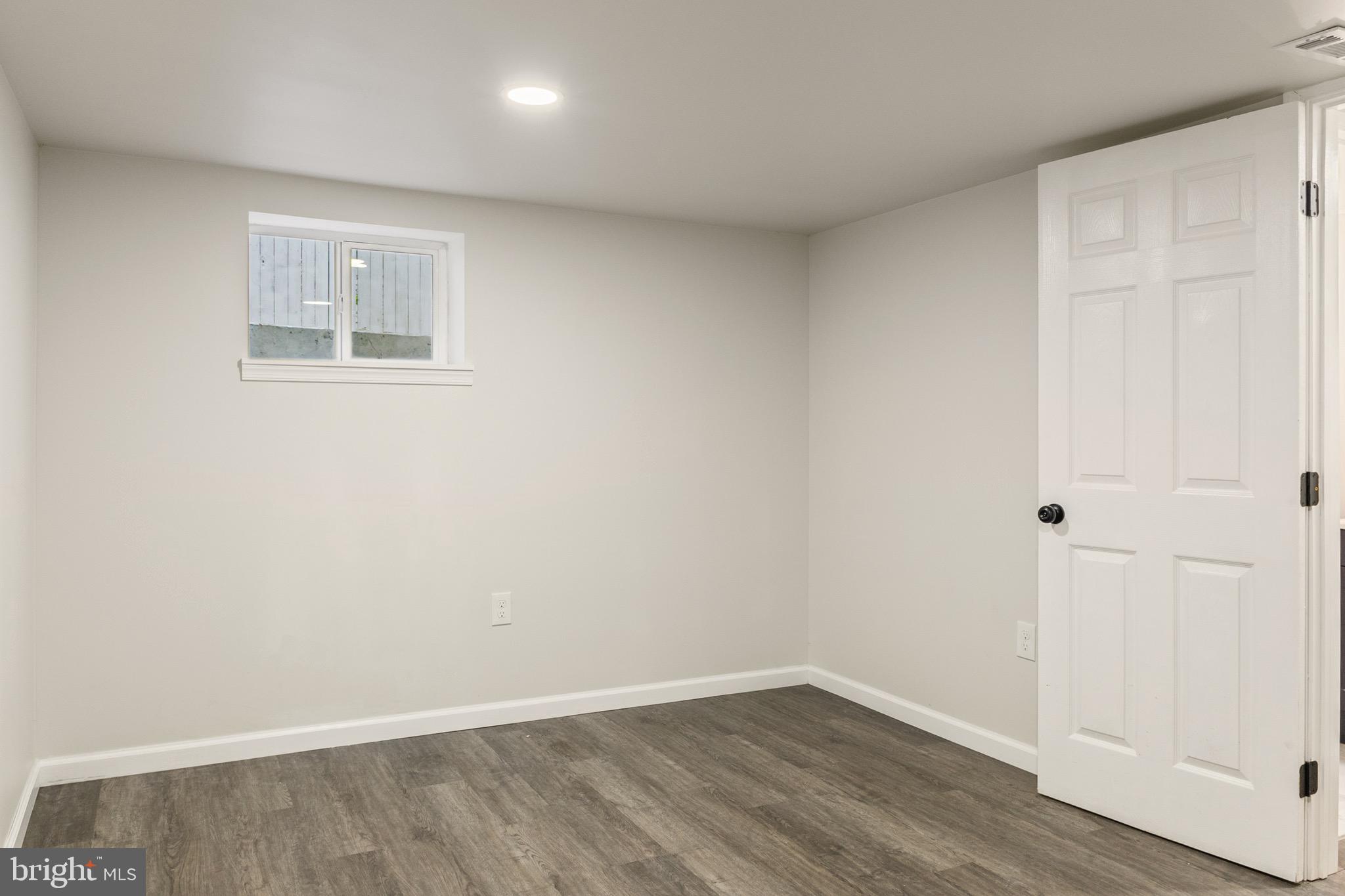 4042 6th Street Baltimore, MD 21225 - Photo 22 of 31 an empty room with wooden floor and windows