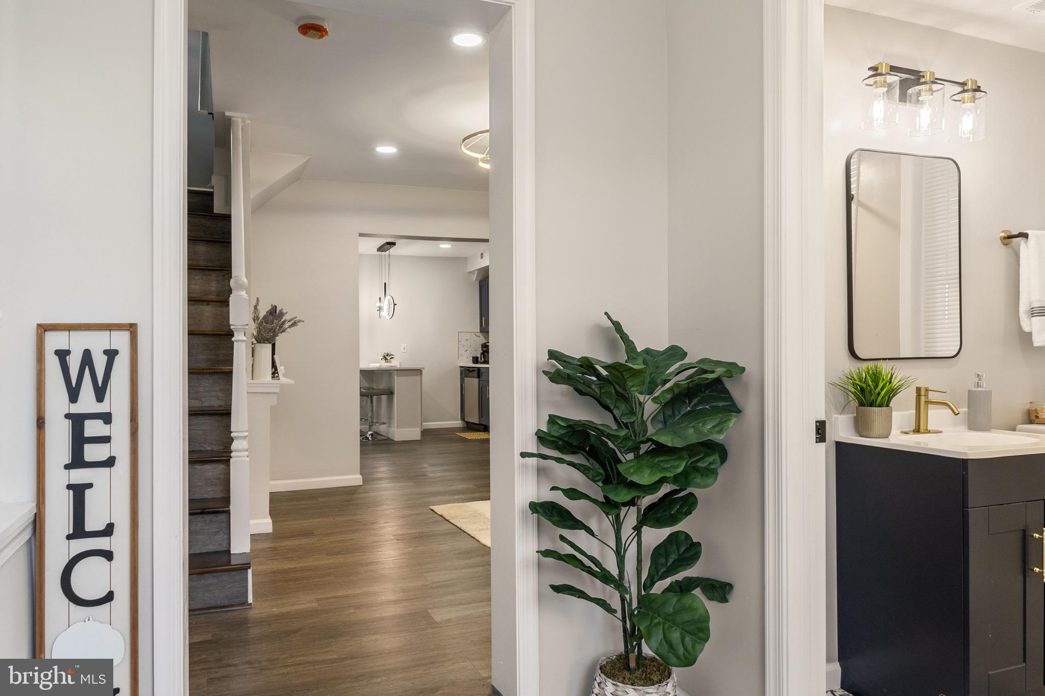 4042 6th Street Baltimore, MD 21225 - Photo 5 of 31 a view of a hallway with wooden floor and a bathroom