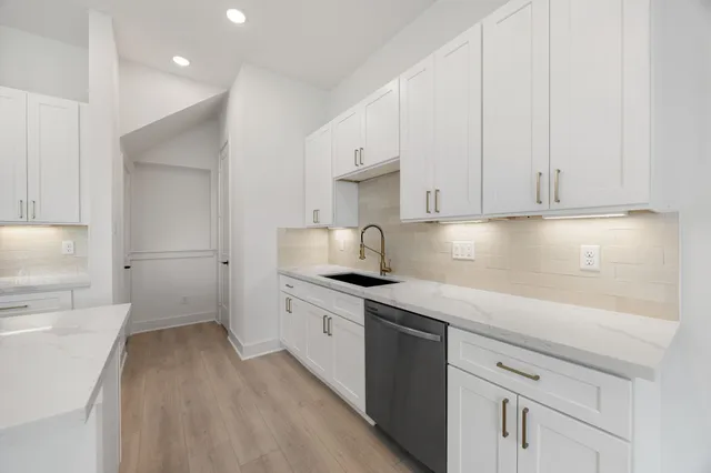 a kitchen with stainless steel appliances granite countertop a sink stove and cabinets