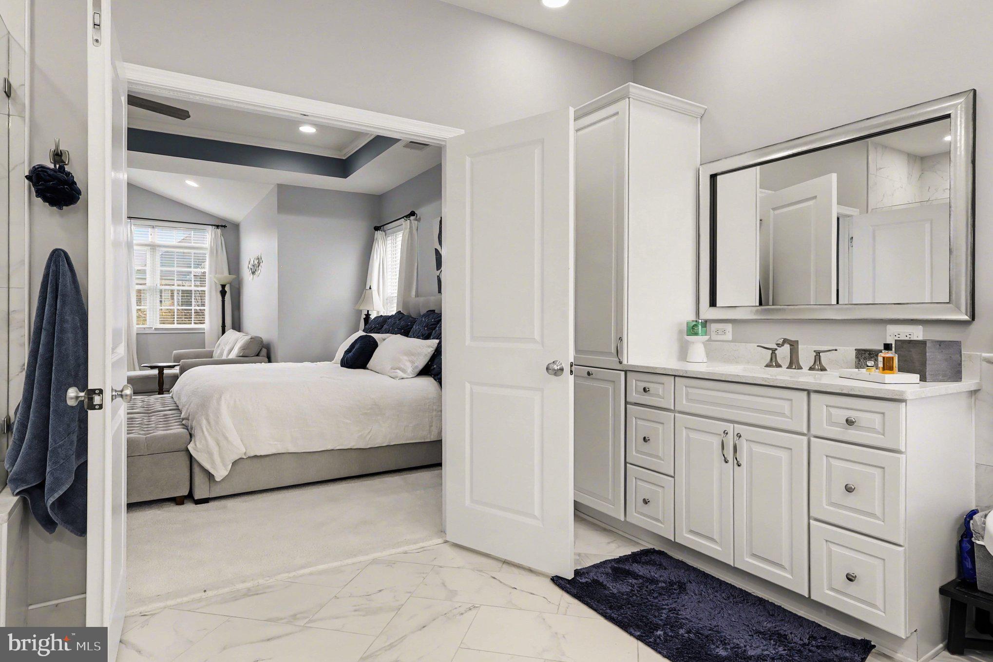 13212 Moonlight Trail Drive Silver Spring, MD 20906 - Photo 40 of 81 a spacious bedroom with a bed a mirror and cabinets