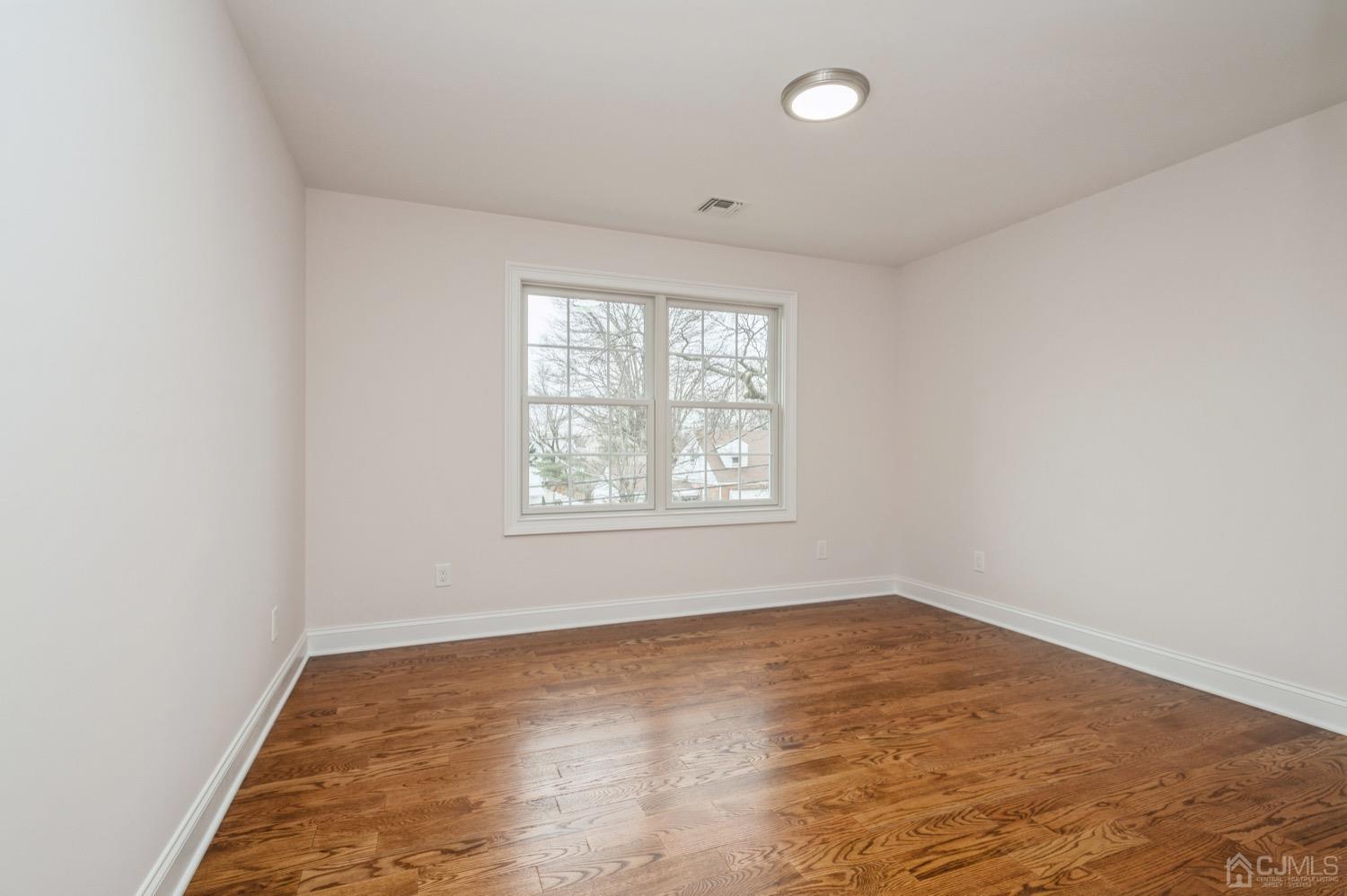 71 South Hill Road Colonia, NJ 07067 - Photo 26 of 40 an empty room with wooden floor and windows