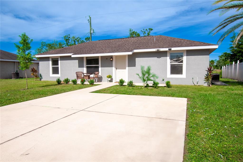 a front view of a house with a yard and potted plants