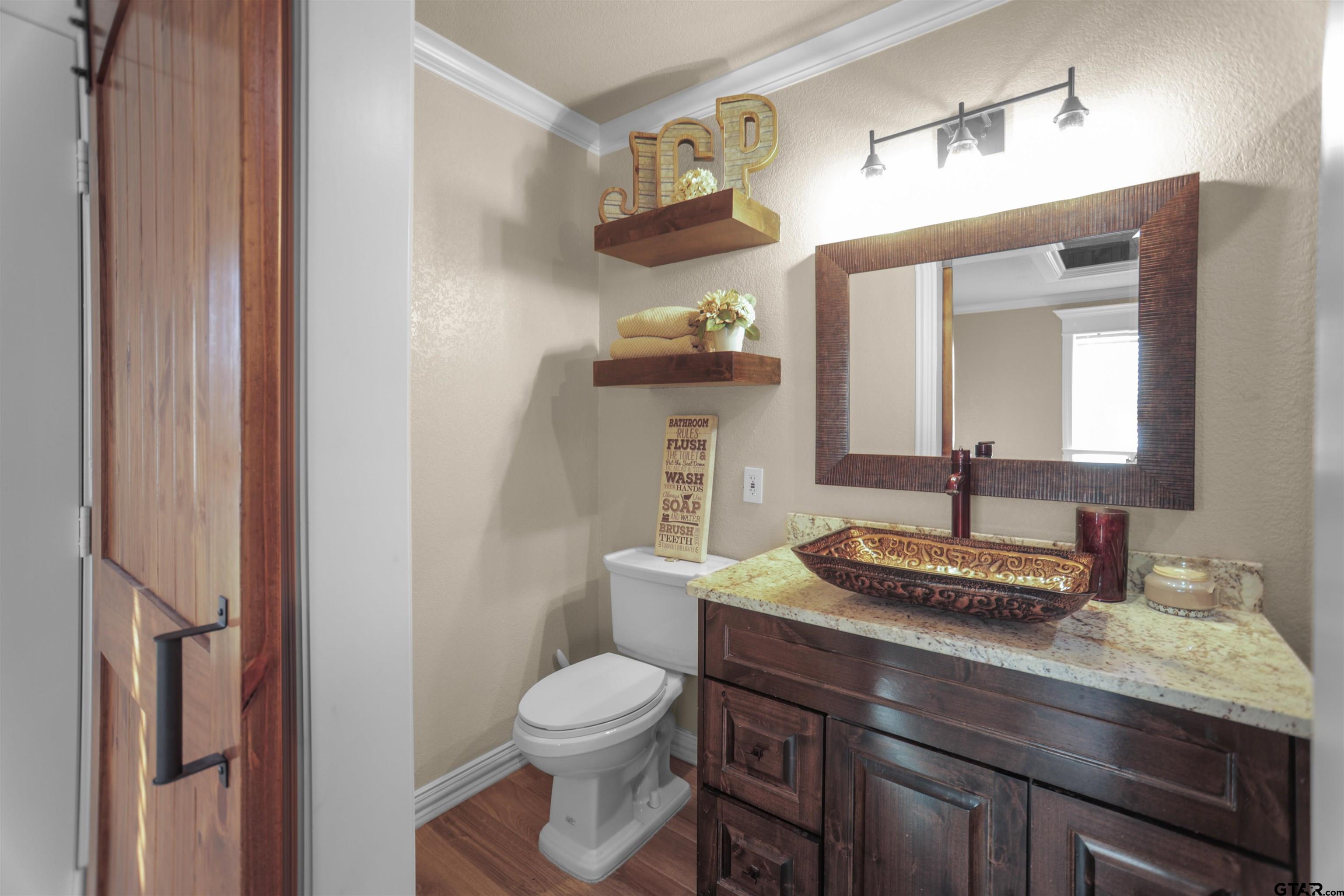 11931 State Highway 64 Tyler, TX 75704 - Photo 15 of 44 a bathroom with a granite countertop toilet sink and mirror