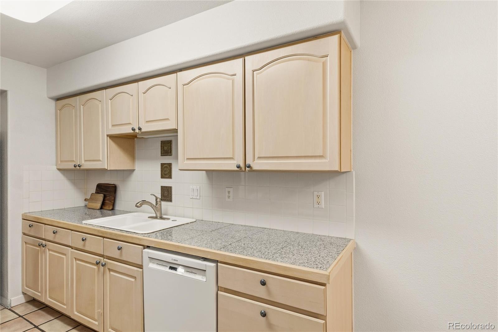 563 Ridgeview Drive Louisville, CO 80027 - Photo 15 of 33 a kitchen with white cabinets and white appliances