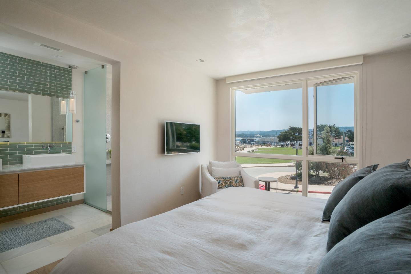 201 Cannery Row, Unit 3 Monterey, CA 93940 - Photo 12 of 19 a bedroom with a bed and large windows