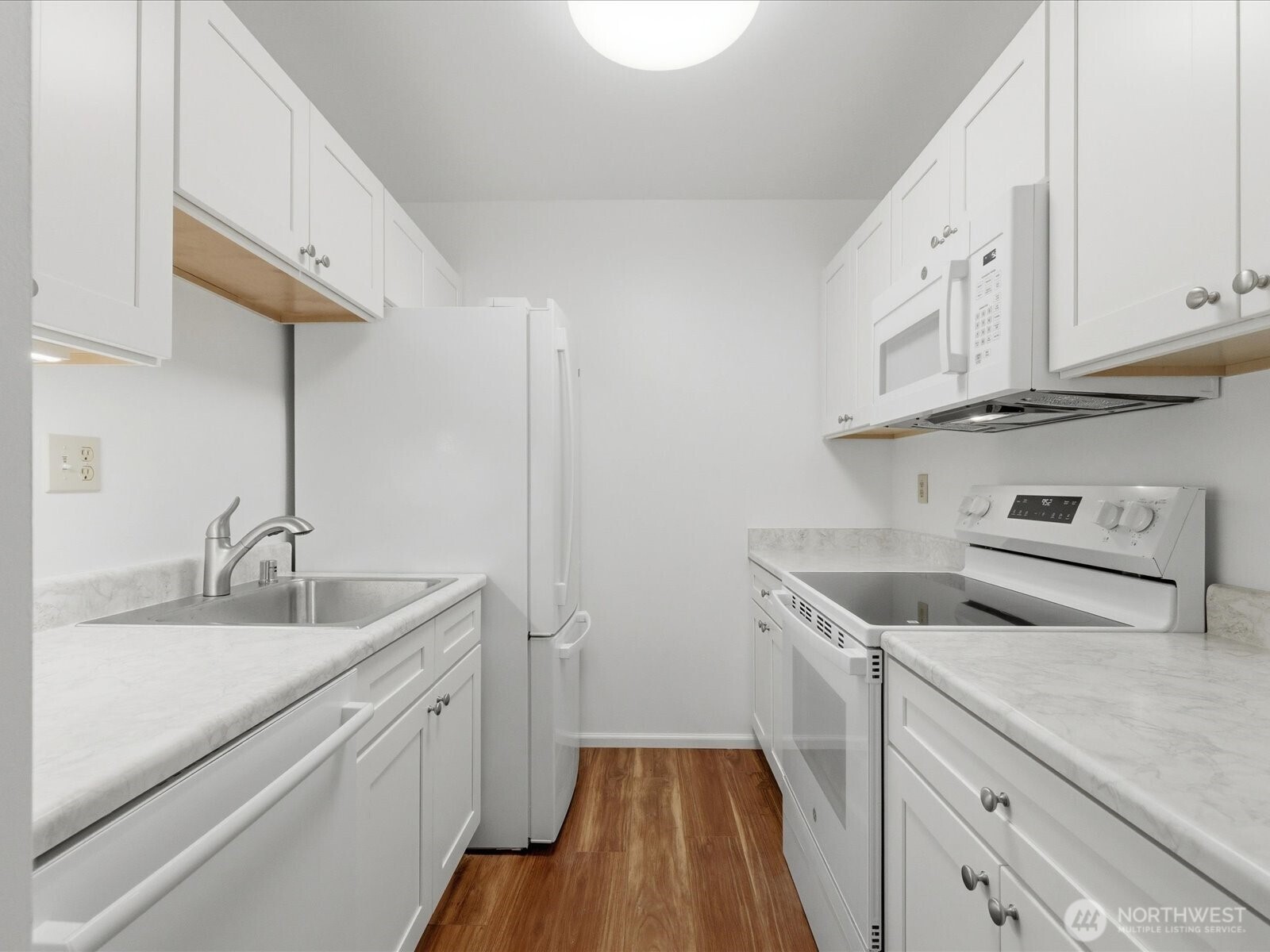 8835 166th Avenue Northeast, Unit D102 Redmond, WA 98052 - Photo 18 of 27 a kitchen with a sink dishwasher and white cabinets with wooden floor