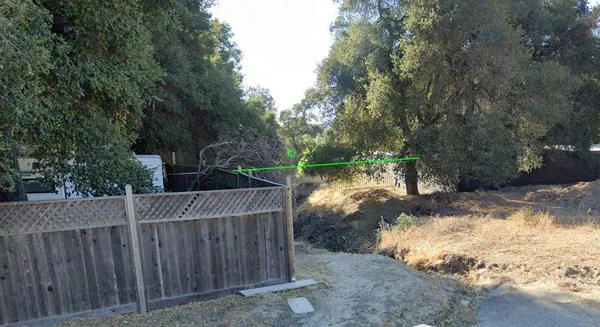 a view of a wooden fence and trees around