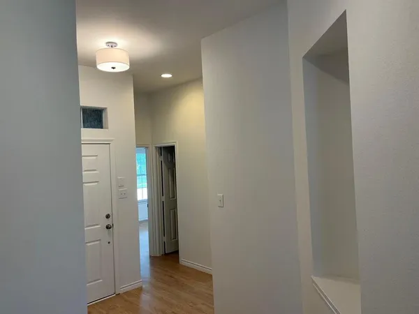 a view of a hallway with wooden floor and closet