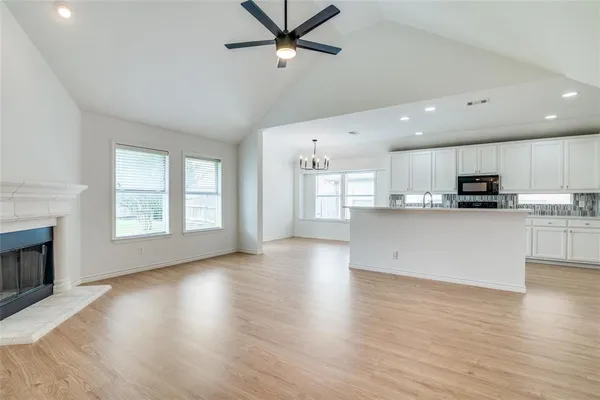 a view of kitchen with cabinets stainless steel appliances and wooden floor