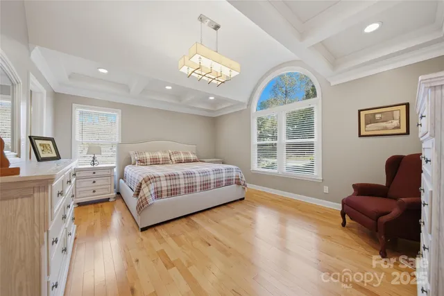 a bedroom with a large bed and a chandelier