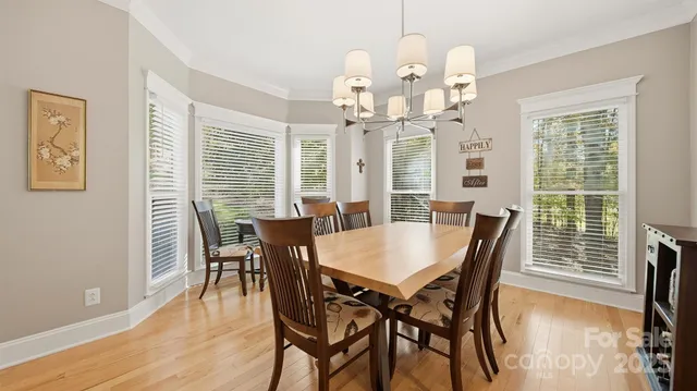 a view of a kitchen with granite countertop a stove a sink a dining table and chairs