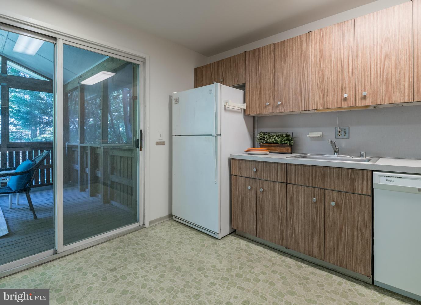 6805 Persimmon Tree Road Bethesda, MD 20817 - Photo 11 of 30 a kitchen with a sink a refrigerator and cabinets