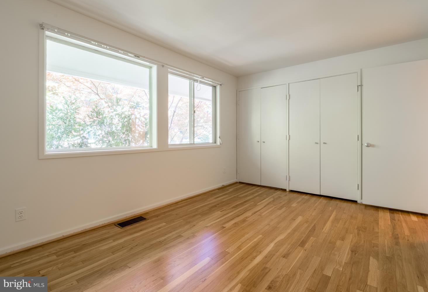 6805 Persimmon Tree Road Bethesda, MD 20817 - Photo 19 of 30 a view of an empty room with wooden floor and a window
