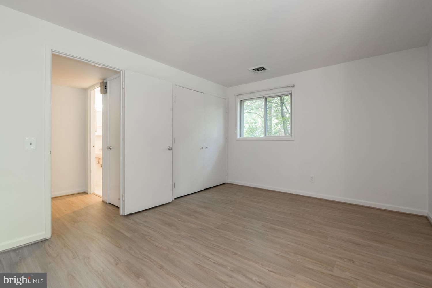 6805 Persimmon Tree Road Bethesda, MD 20817 - Photo 25 of 30 an empty room with wooden floor and windows