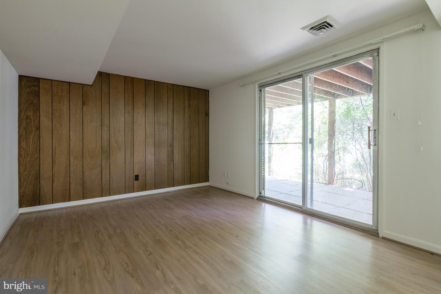 6805 Persimmon Tree Road Bethesda, MD 20817 - Photo 27 of 30 a view of an empty room with wooden floor and a window