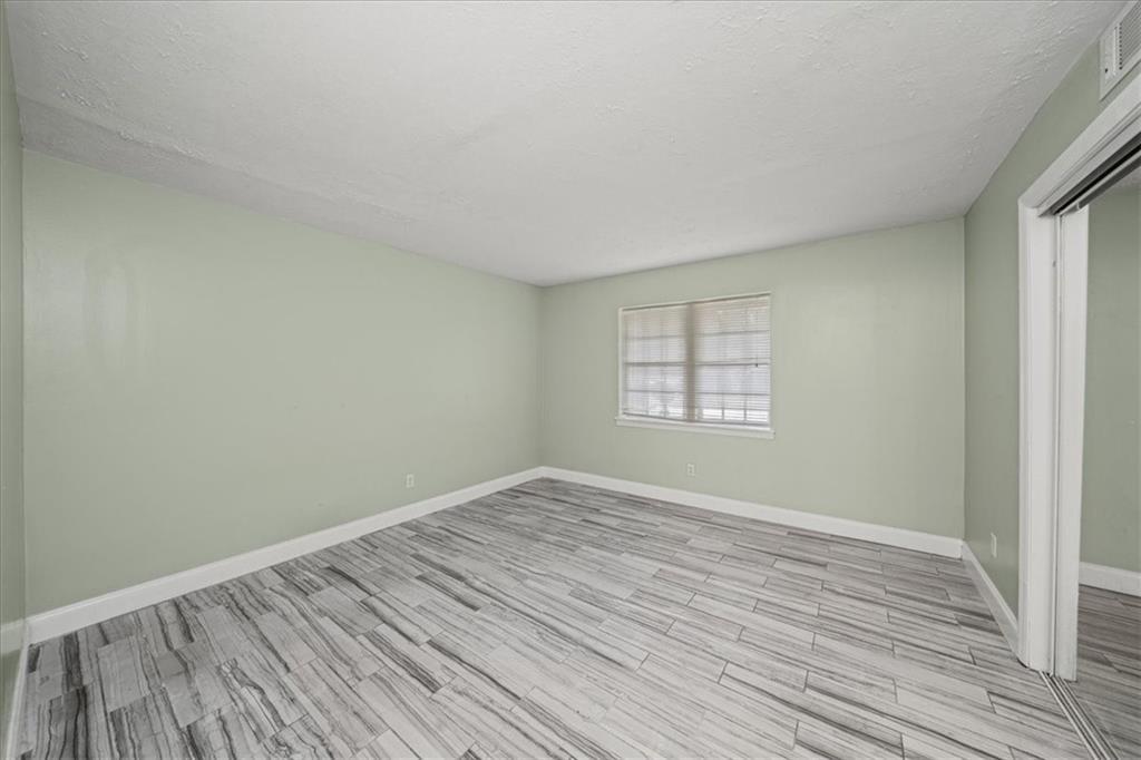 3087 Colonial Way, Unit J Atlanta, GA 30341 - Photo 15 of 21 an empty room with wooden floor and windows