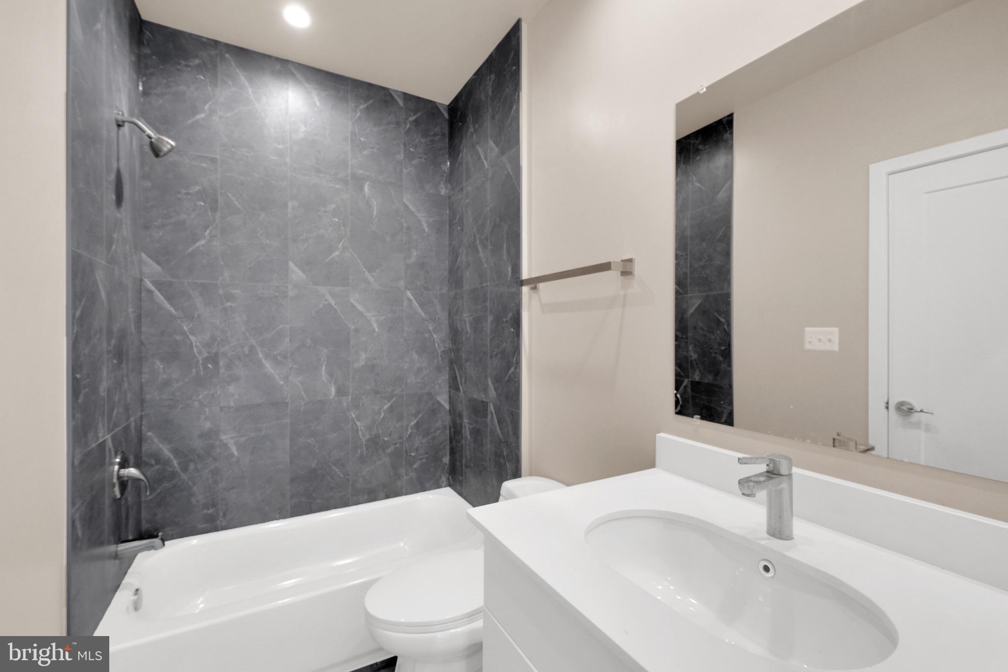 854 Xenia Street Southeast, Unit 102 Washington, DC 20032 - Photo 14 of 28 a bathroom with a toilet a sink and a bathtub