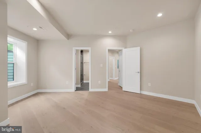 an empty room with windows and closet