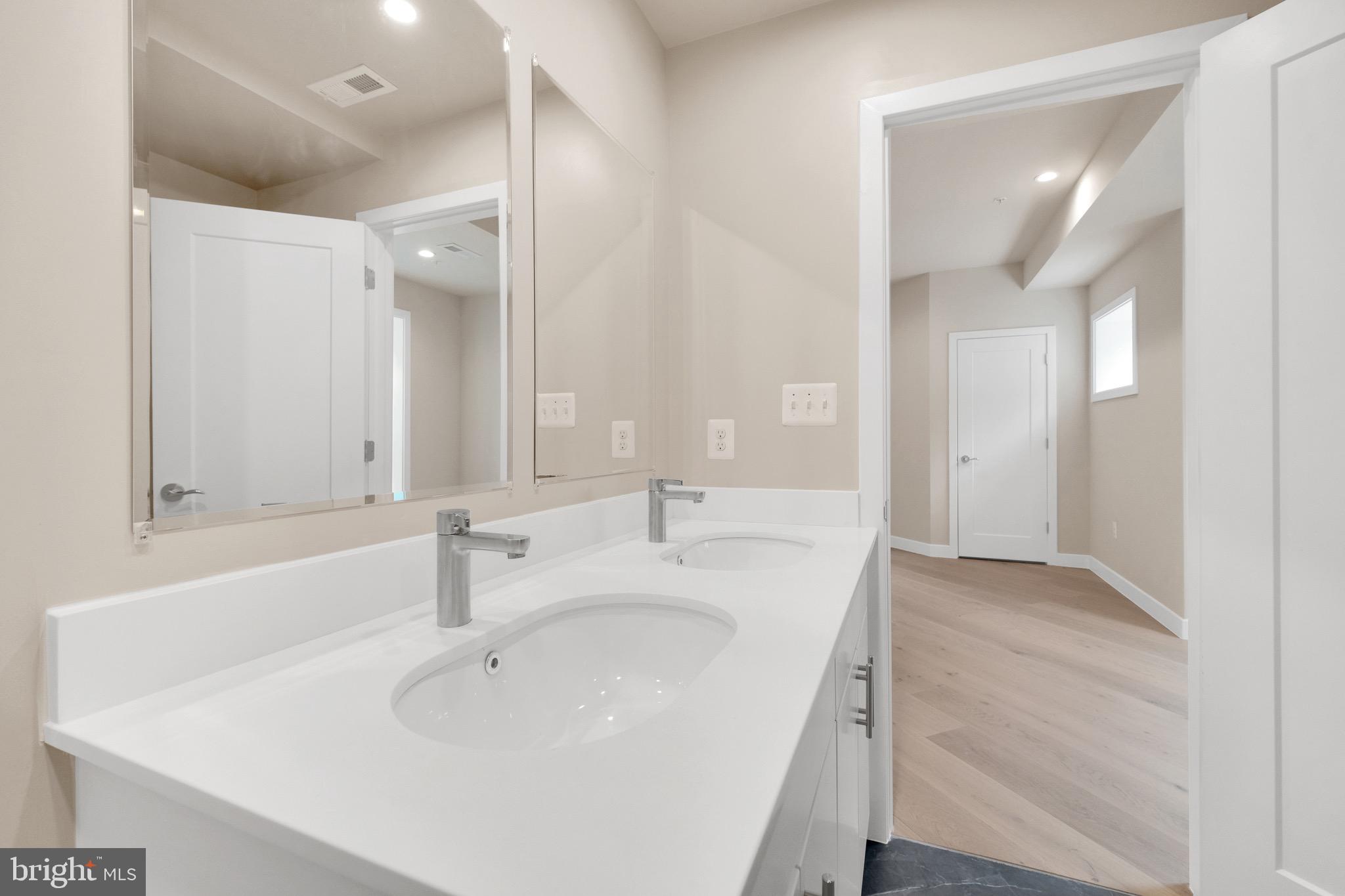 854 Xenia Street Southeast, Unit 102 Washington, DC 20032 - Photo 25 of 28 a bathroom with a sink and a large mirror