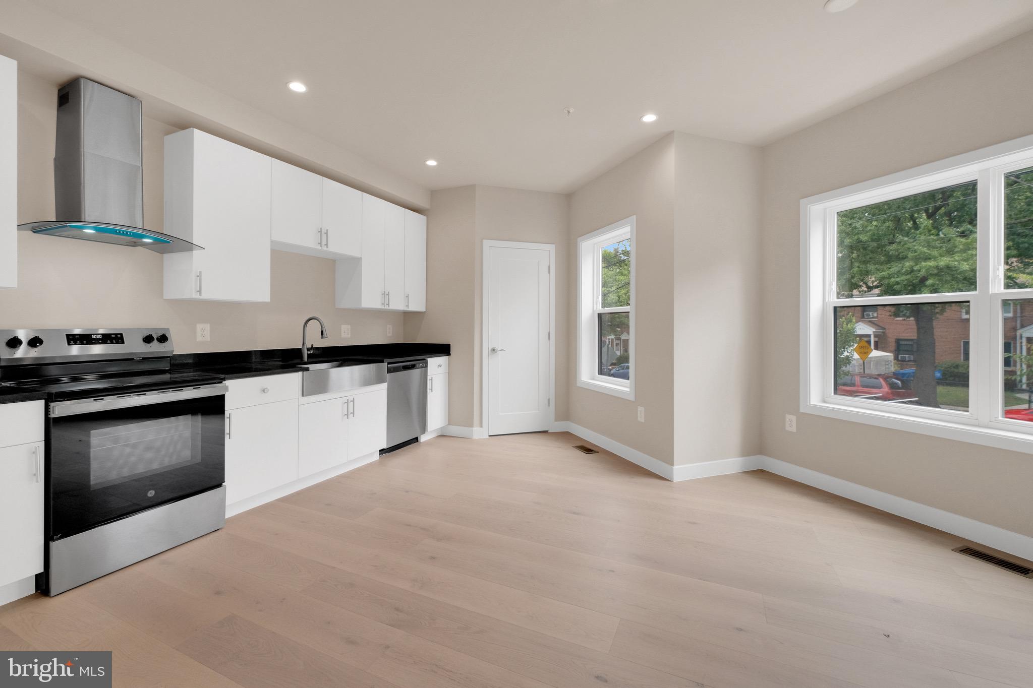 854 Xenia Street Southeast, Unit 102 Washington, DC 20032 - Photo 5 of 28 a kitchen with granite countertop white cabinets and window