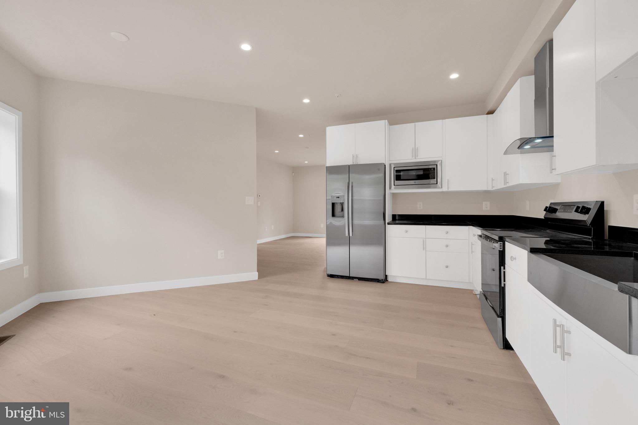 854 Xenia Street Southeast, Unit 102 Washington, DC 20032 - Photo 6 of 28 a kitchen with stainless steel appliances granite countertop a refrigerator and a sink