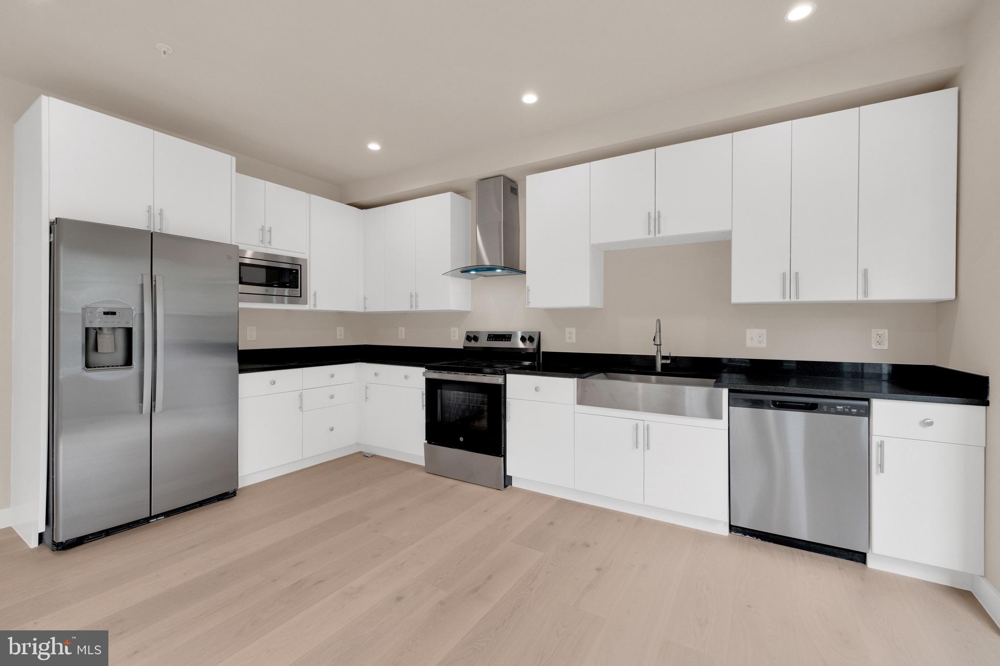 854 Xenia Street Southeast, Unit 102 Washington, DC 20032 - Photo 7 of 28 a kitchen with granite countertop white cabinets and stainless steel appliances