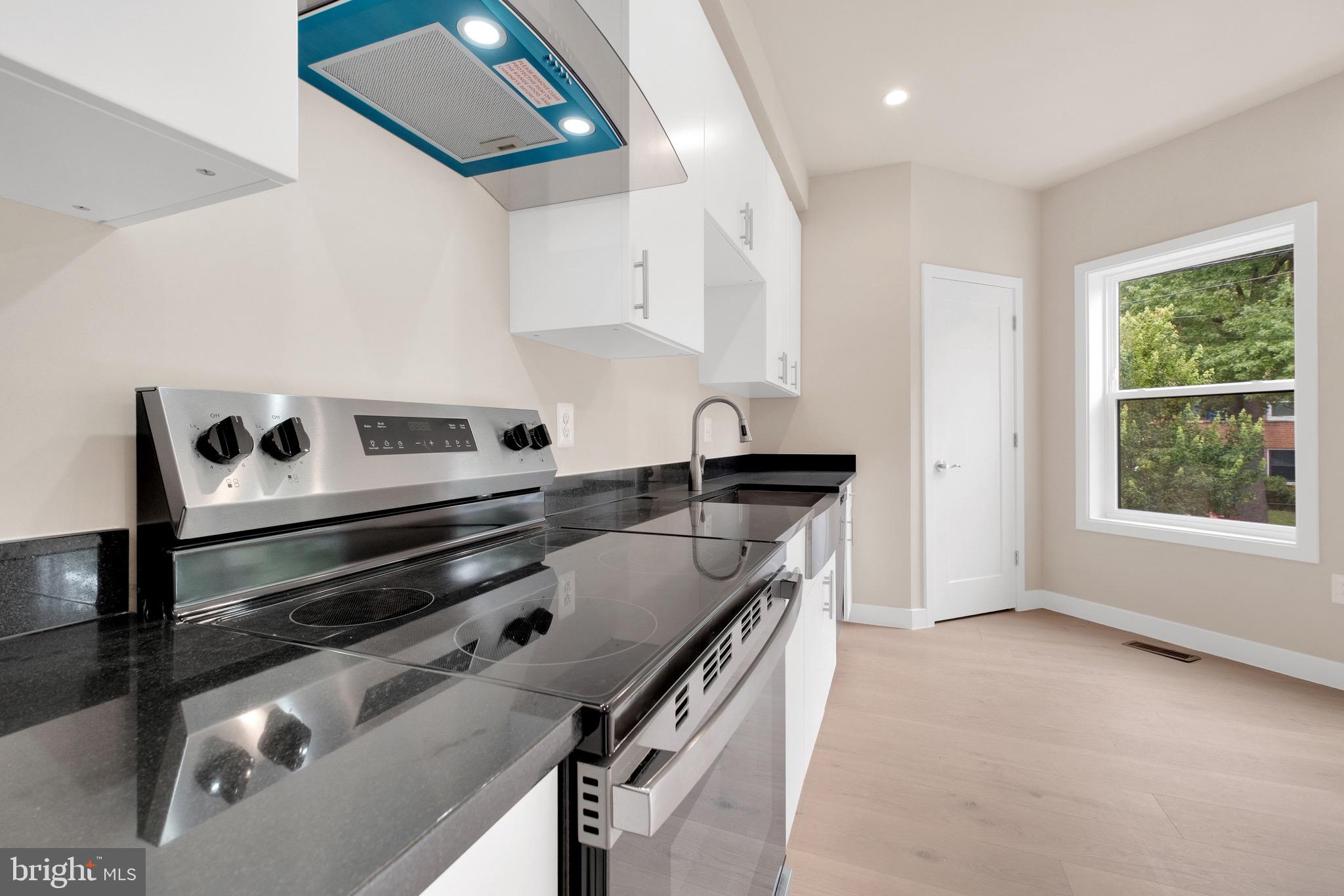 854 Xenia Street Southeast, Unit 102 Washington, DC 20032 - Photo 9 of 28 a kitchen with a stove and a white cabinets