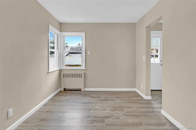 an empty room with wooden floor and a window