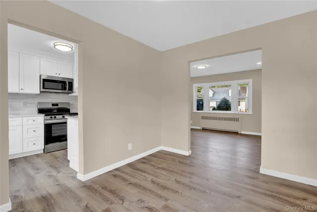 a view of a kitchen with a sink stove cabinets and empty room
