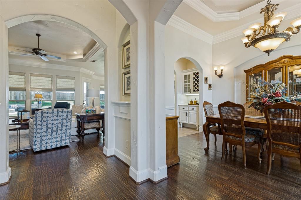 229 Arbor Lane Haslet, TX 76052 - Photo 5 of 34 Formal dining area featuring wood-finish flooring, a multi-tiered ceiling with crown molding, and an ornate chandelier