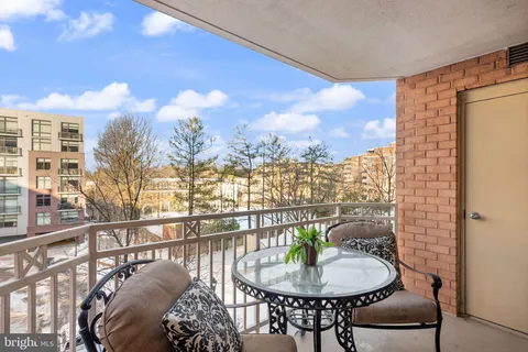a balcony with table and chairs