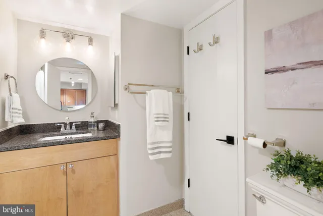 a bathroom with a granite countertop sink a mirror and shower