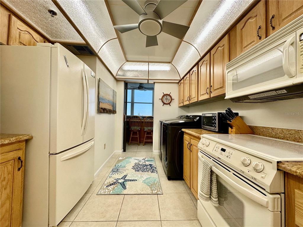 15462 Gulf Boulevard, Unit 501 Madeira Beach, FL 33708 - Photo 53 of 88 a kitchen with stainless steel appliances granite countertop a refrigerator a stove and a sink with cabinets