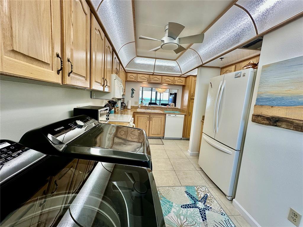 15462 Gulf Boulevard, Unit 501 Madeira Beach, FL 33708 - Photo 62 of 88 a kitchen with stainless steel appliances granite countertop a refrigerator a sink dishwasher a stove and white countertops with cabinets