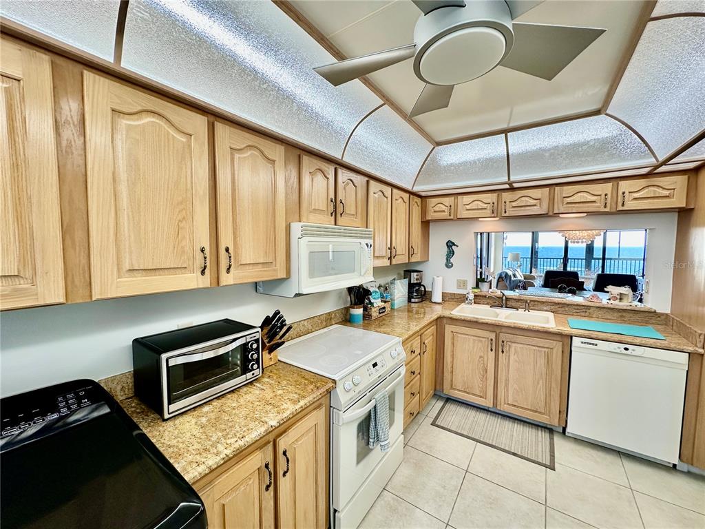 15462 Gulf Boulevard, Unit 501 Madeira Beach, FL 33708 - Photo 65 of 88 a kitchen with a stove sink and cabinets