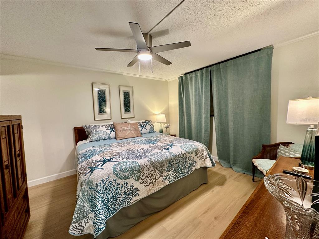15462 Gulf Boulevard, Unit 501 Madeira Beach, FL 33708 - Photo 72 of 88 a bedroom with a bed and a lamp on dresser
