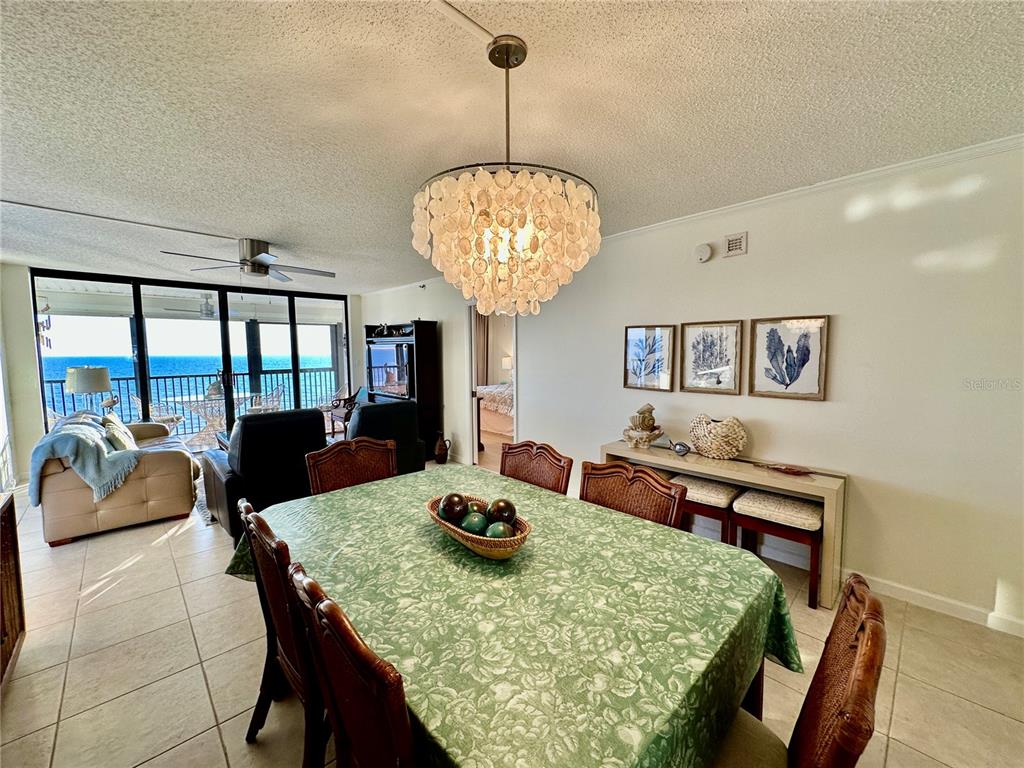 15462 Gulf Boulevard, Unit 501 Madeira Beach, FL 33708 - Photo 81 of 88 a view of a dining room with furniture a chandelier and wooden floor