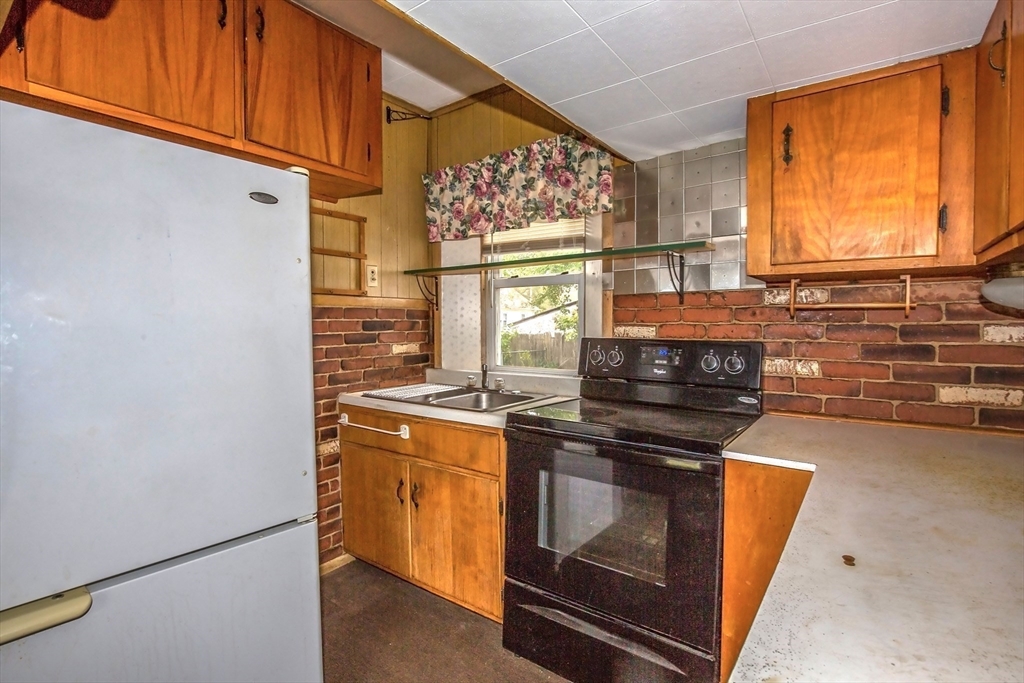 94 Duryea Street Springfield, MA 01104 - Photo 8 of 33 a kitchen with stainless steel appliances granite countertop a stove a sink and a refrigerator